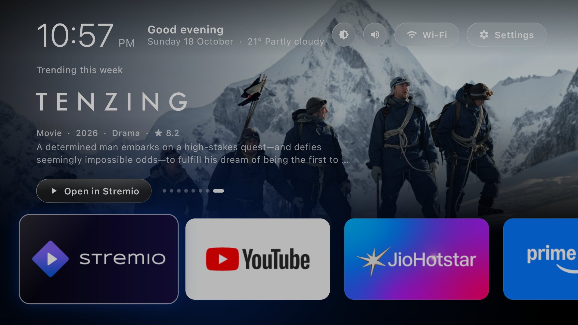 The final launcher: frosted glass buttons over a trending title backdrop, rows running off the screen edge, a softly glowing focused tile