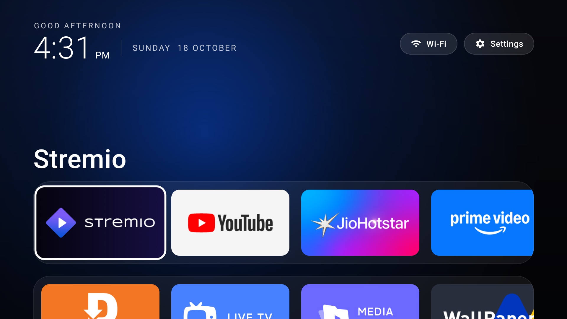 The first version of the custom launcher: large clock, greeting, Wi-Fi and Settings buttons, app name in large text and a row of app tiles over a blue glow